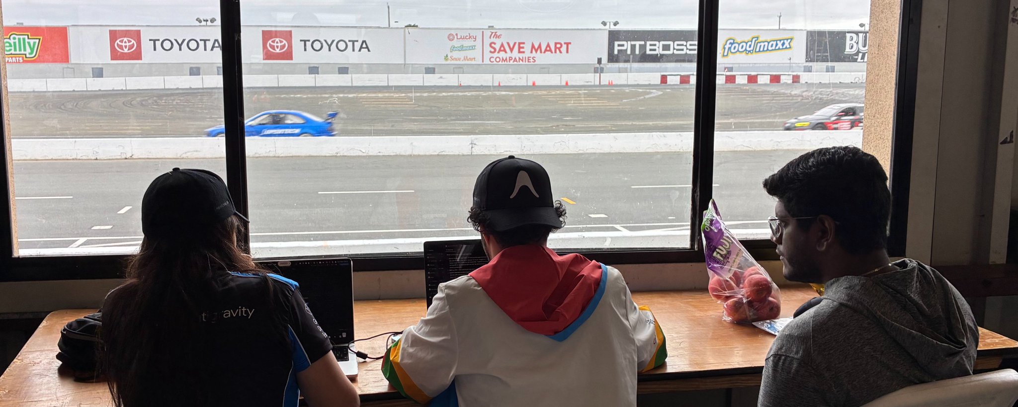 Collaborating on laptops with the GDE cohort beside a racetrack